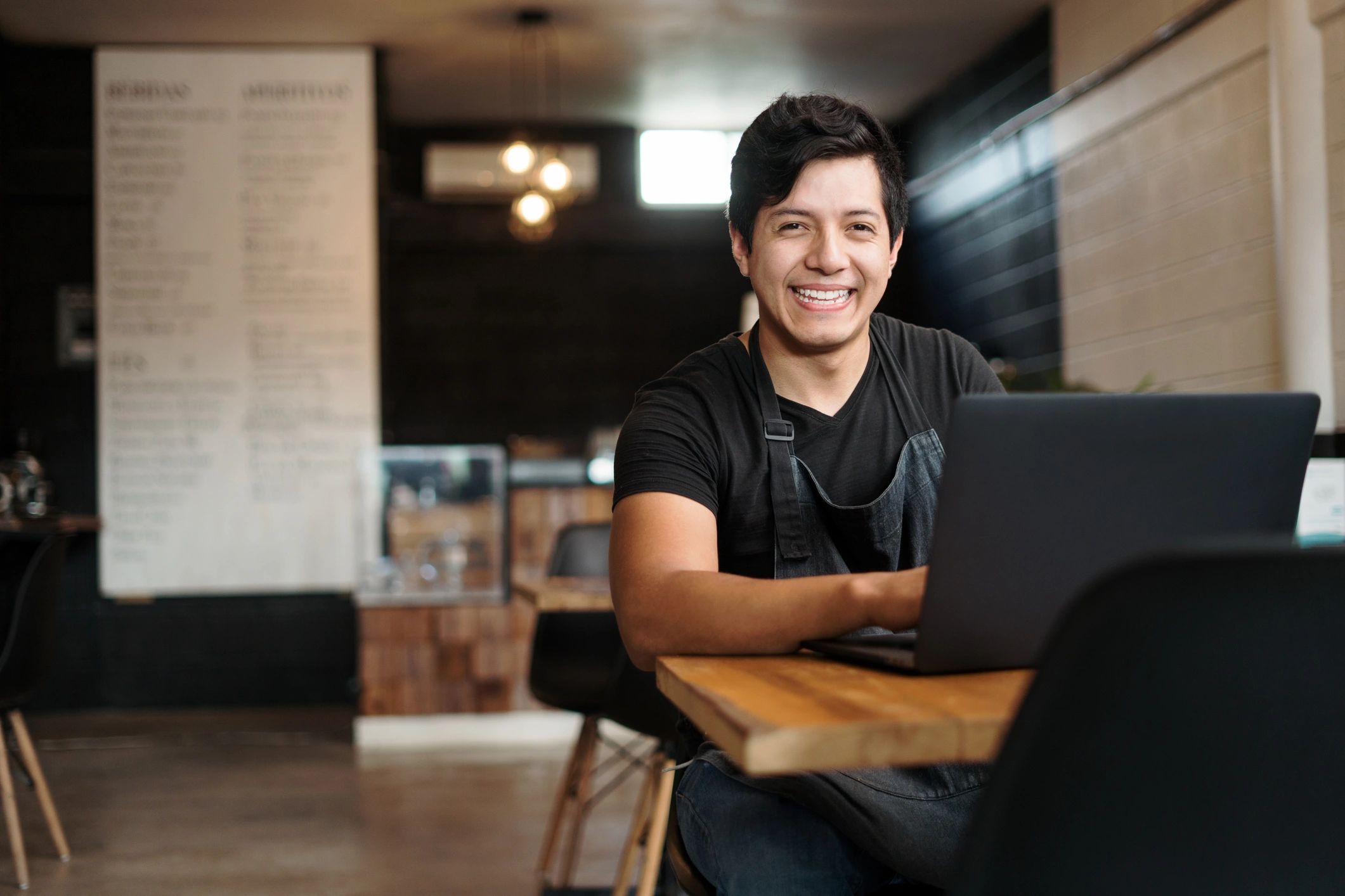 Restaurant owner working on a laptop in a cafe