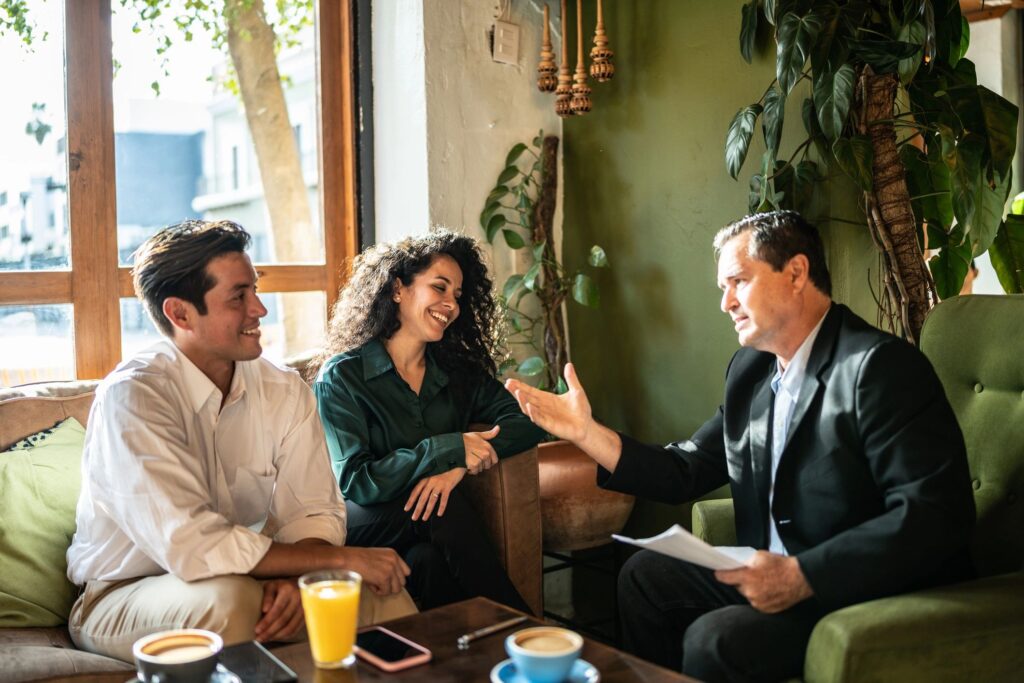 Mid adult couple having a meeting with a financial advisor at a coffee shop