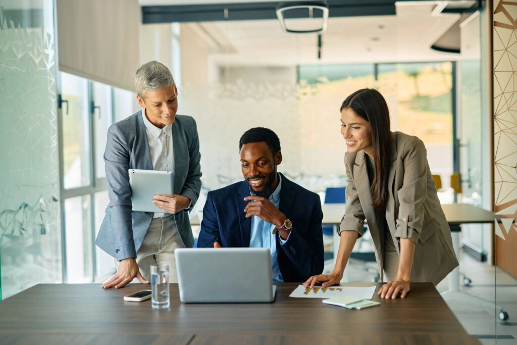 Business team collaborating on a project using laptop in modern office